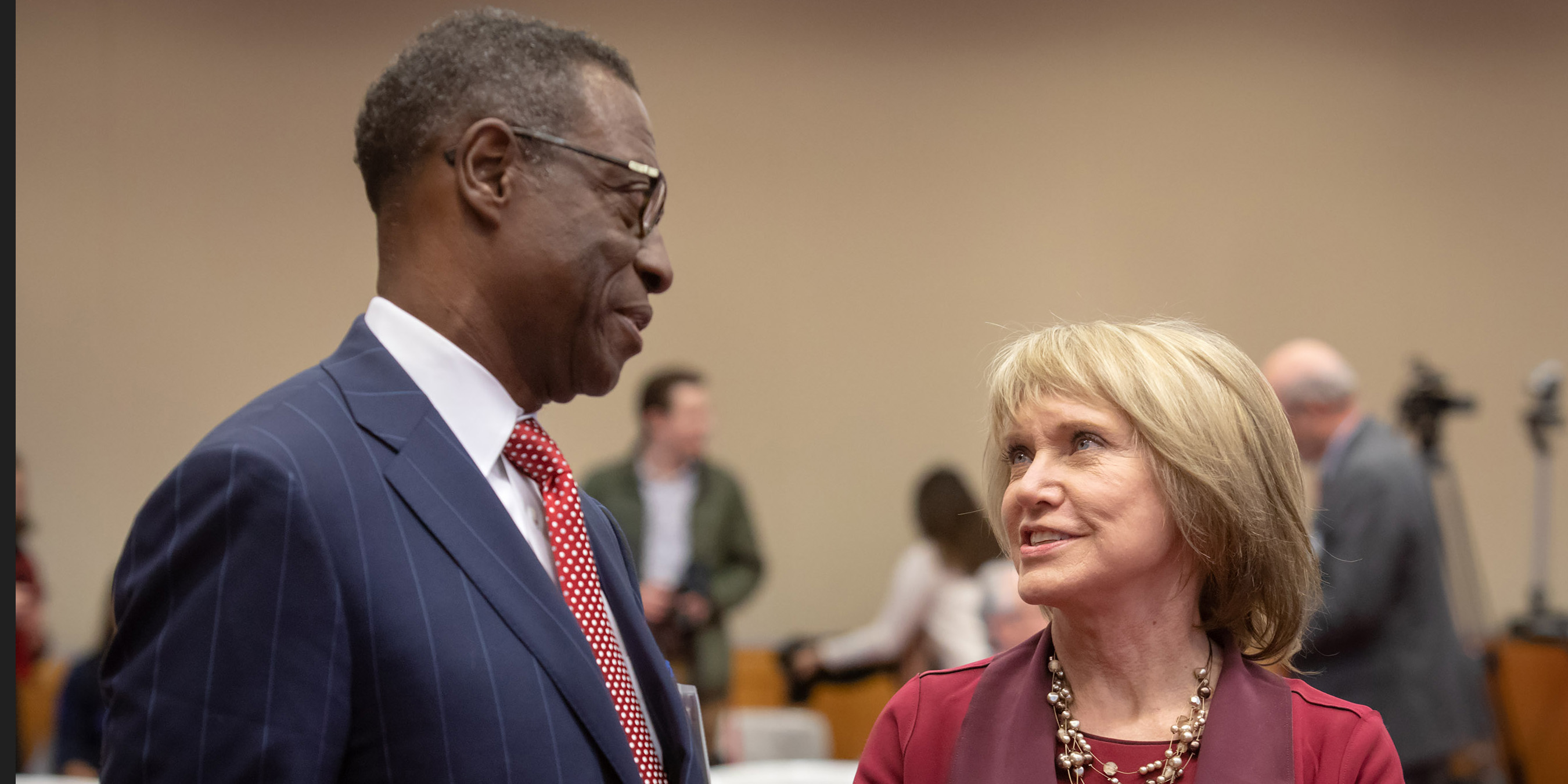 A photo of a man and woman talking at the Dallas Herring Lecture