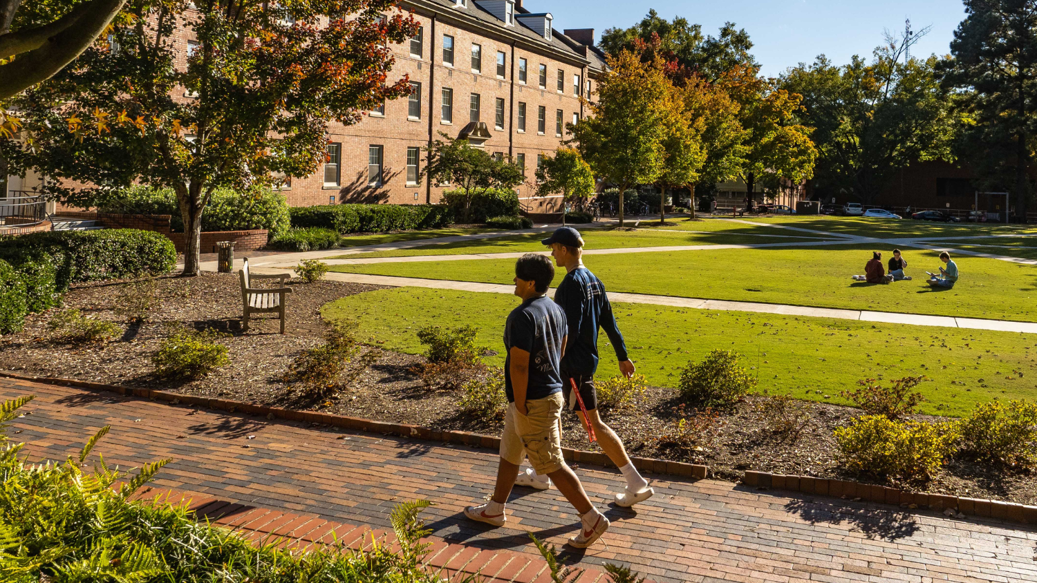 Students walk by Turrlington Residence Hall during a fall day. Photo by Marc Hal