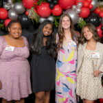 A group of four scholarship recipients standing in front of a balloon backdrop at the NC State College of Education's Scholarships Banquet