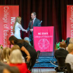 Science education major Rylee Sherwood shakes hands with Executive Director of Philanthropy Matt Friedrick at the 2024 Scholarships Banquet.