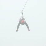 A zipliner flying through the fog.