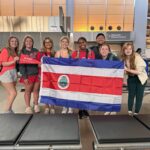 Transformational Scholars unfurling the Costa Rican flag at Raleigh-Durham International Airport.