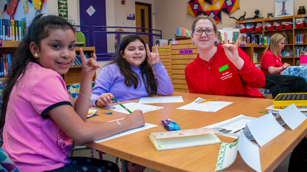 Transformational Scholar and elementary education major Katie Dodson shows her student how to perfect their wolfie hands.