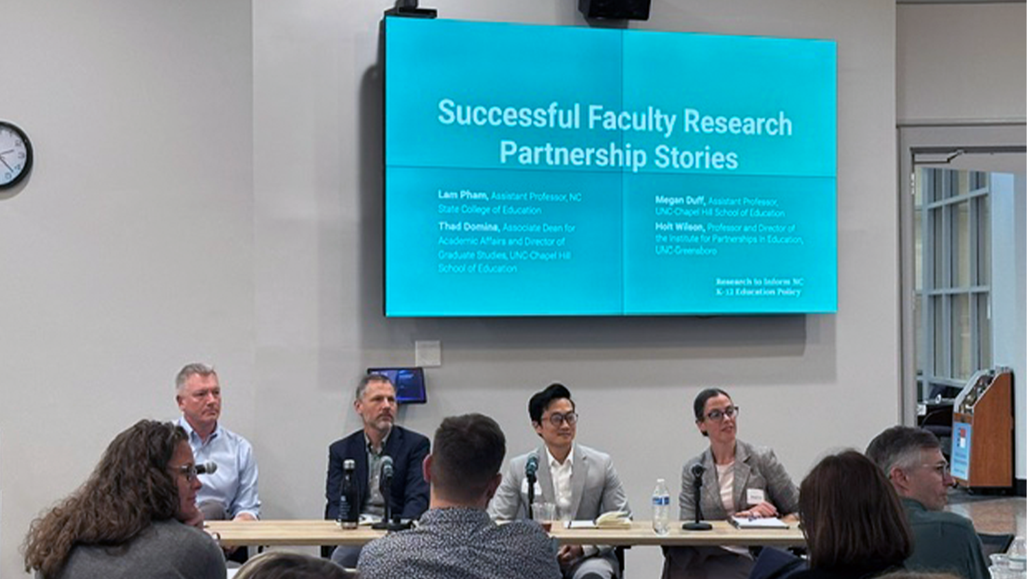 Lam Pham sits at a table with other researches during a panel discussion.
