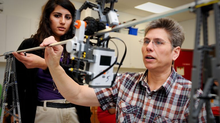 Student and teacher working with robot