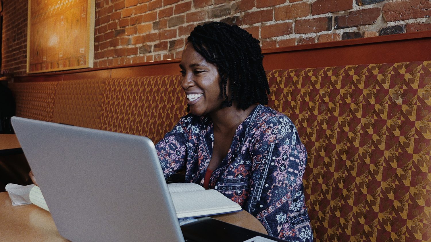 A photo of Iwinosa Idahor at a cafe meeting with a community member