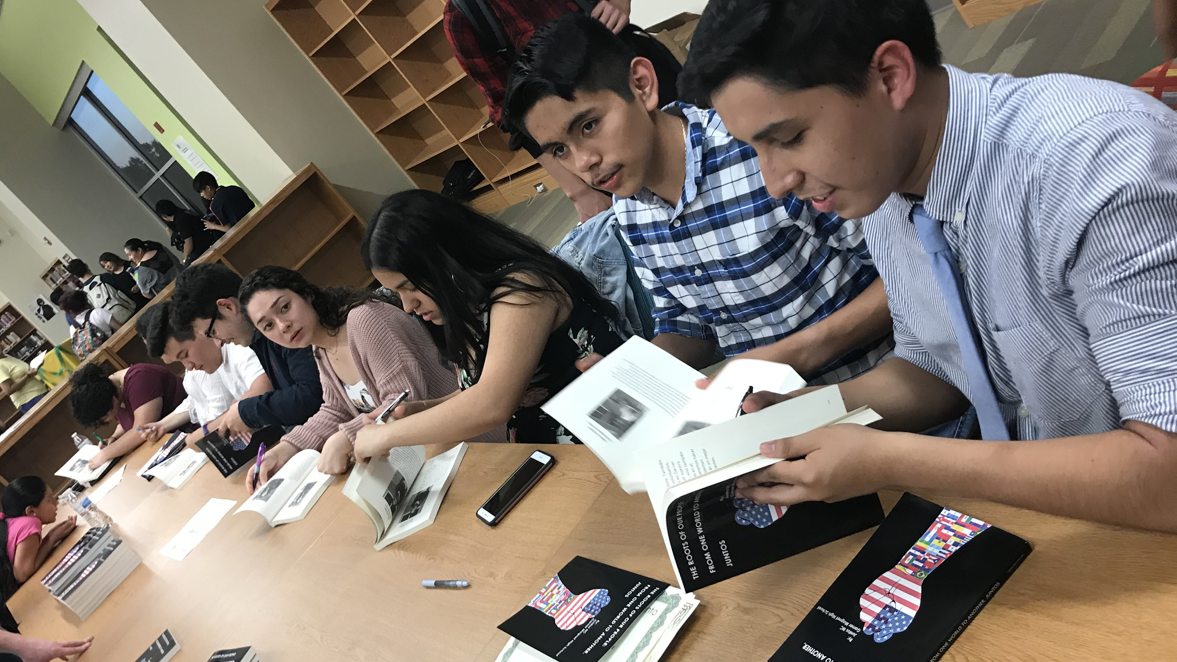 Photo of Juntos NC student authors signing copies of their recently published book.