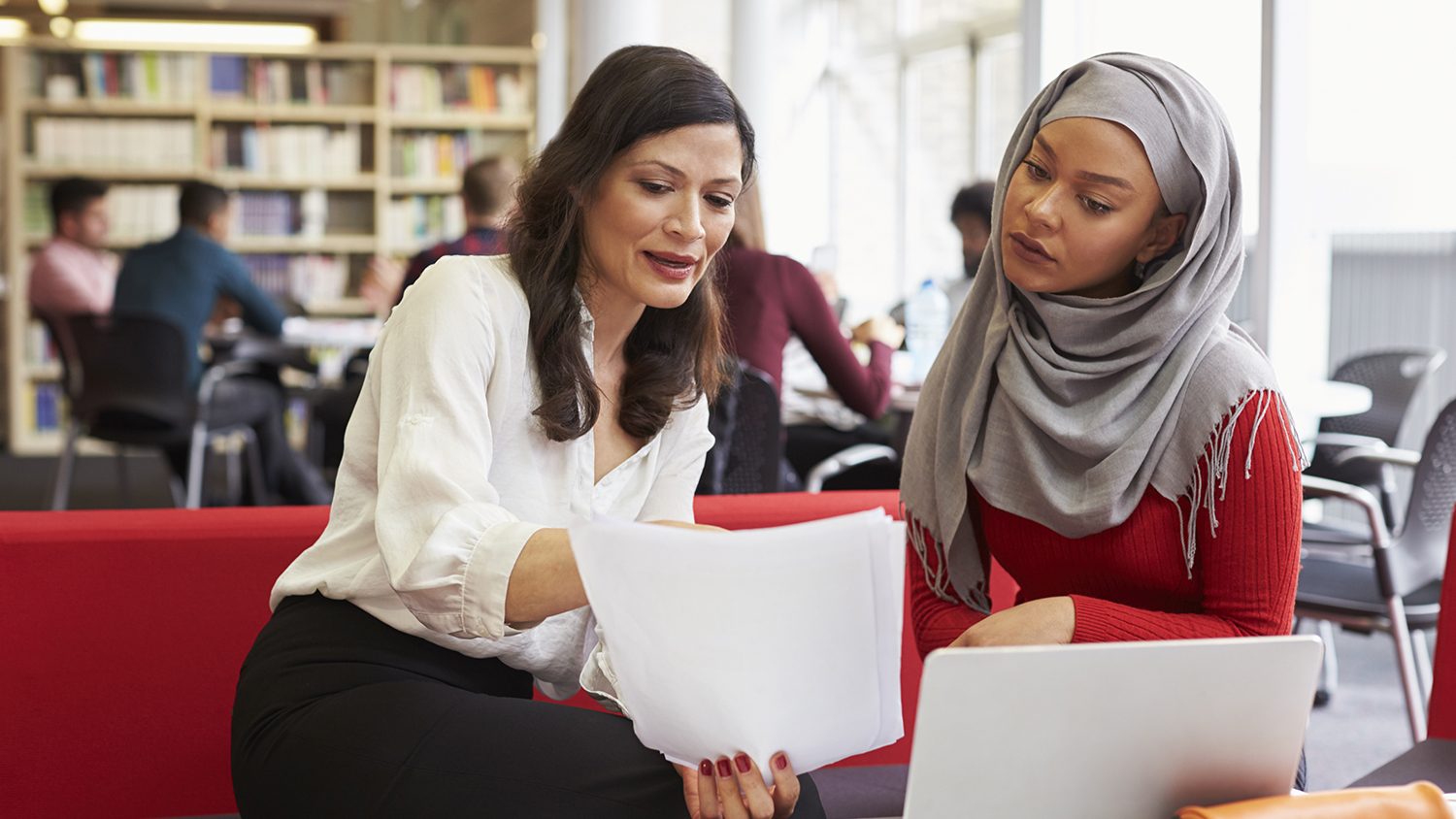 Photo of a faculty member reviewing documents with a female student