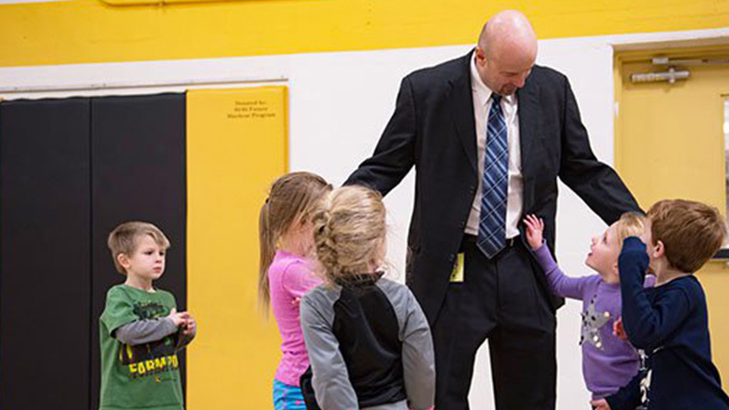 An elementary school principal with young students.