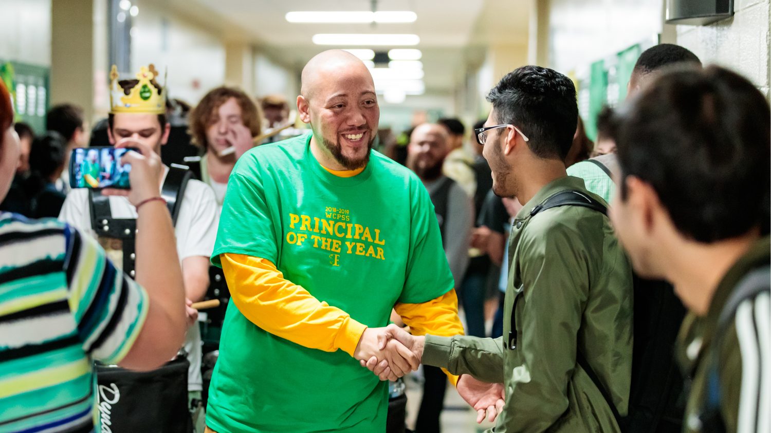 Will Chavis in school hallway shaking hands with students