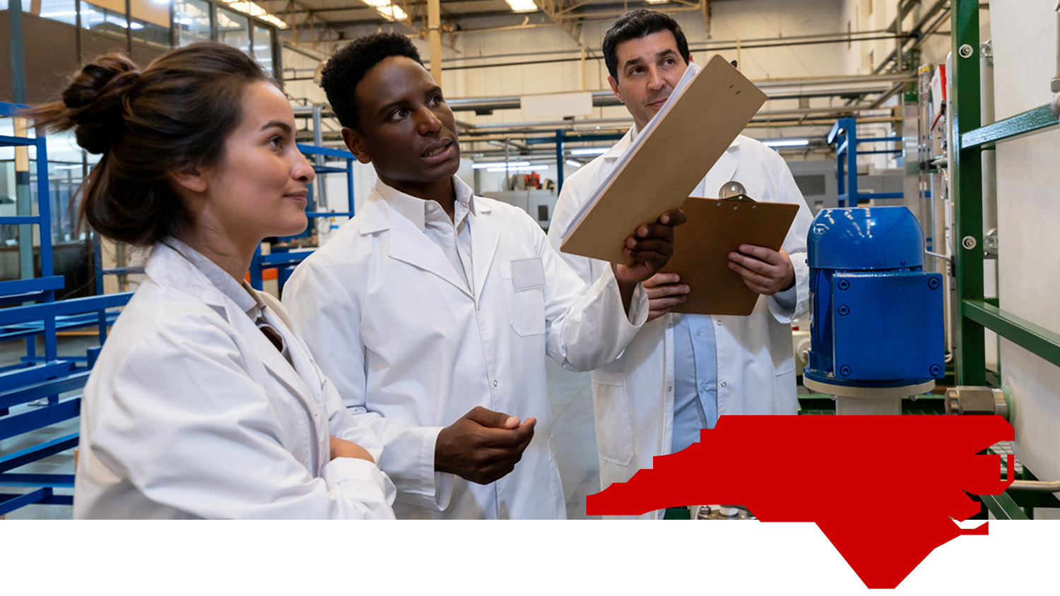 A group of workers in lab coats examine a proejct