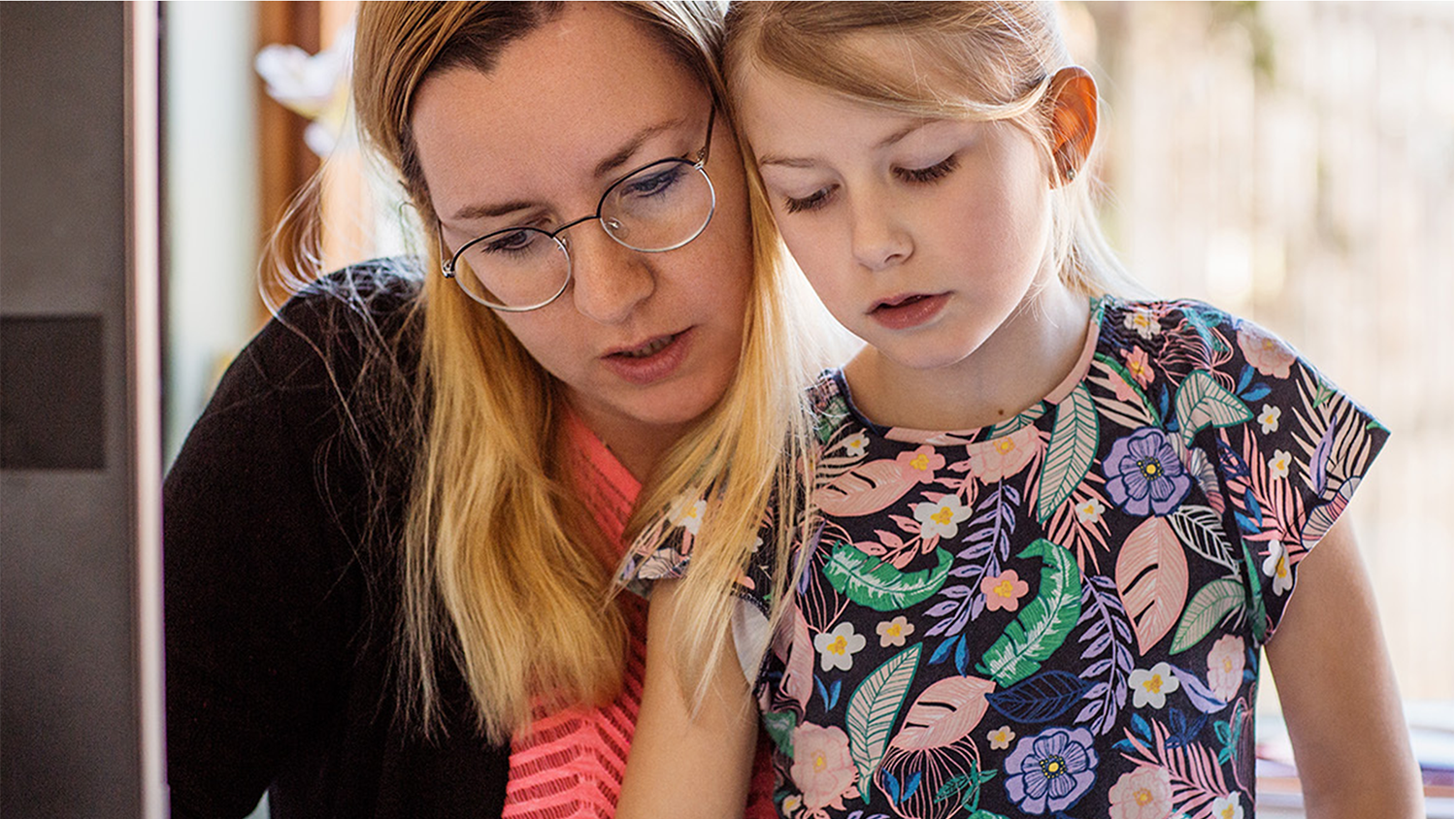 A woman helps a child with homework