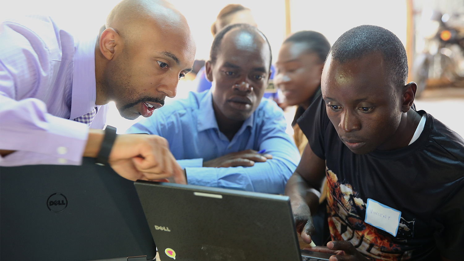 NC State College of Education Associate Professor DeLeon Gray helps students on a computer