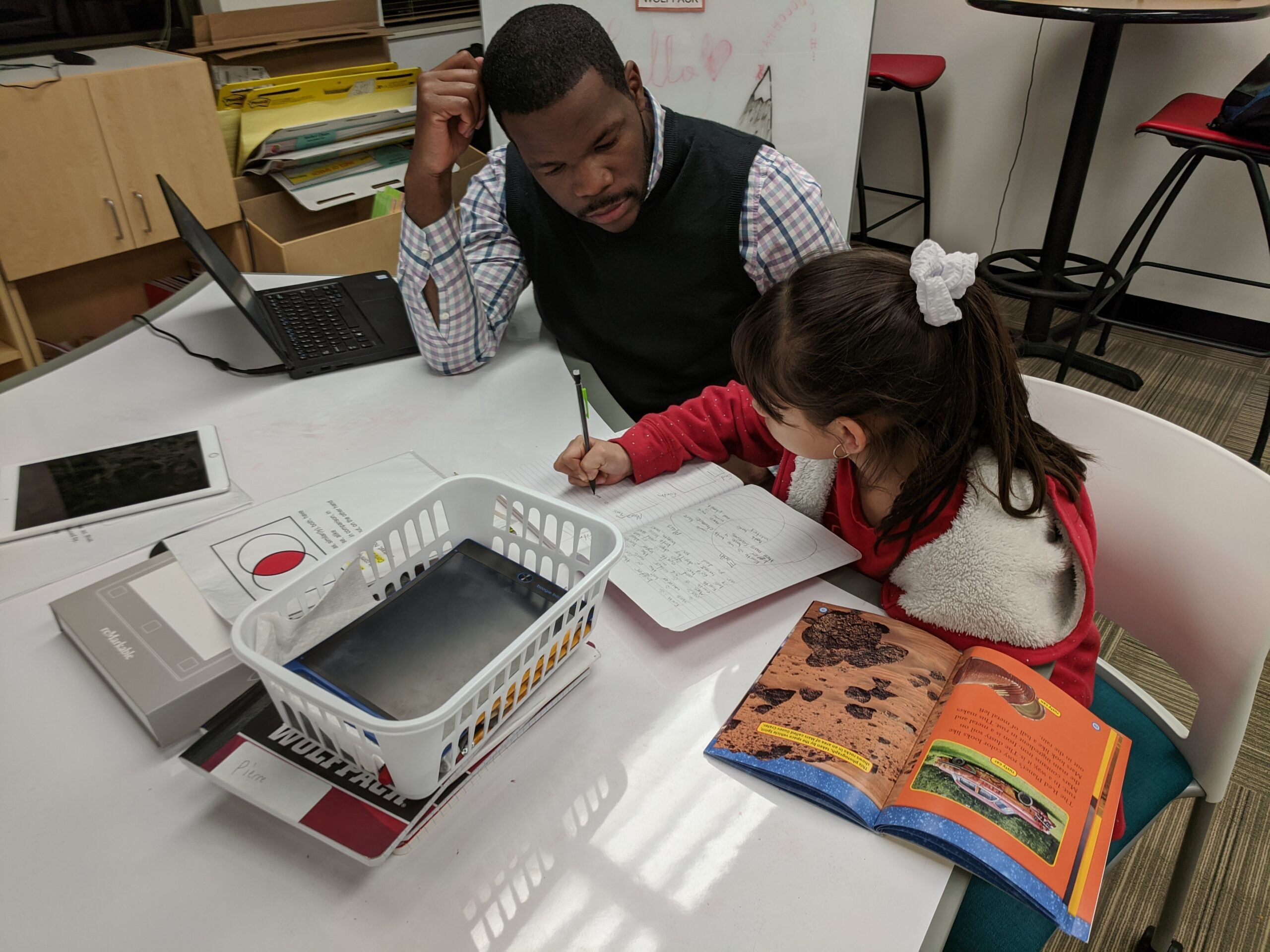 A teacher and student working at a desk