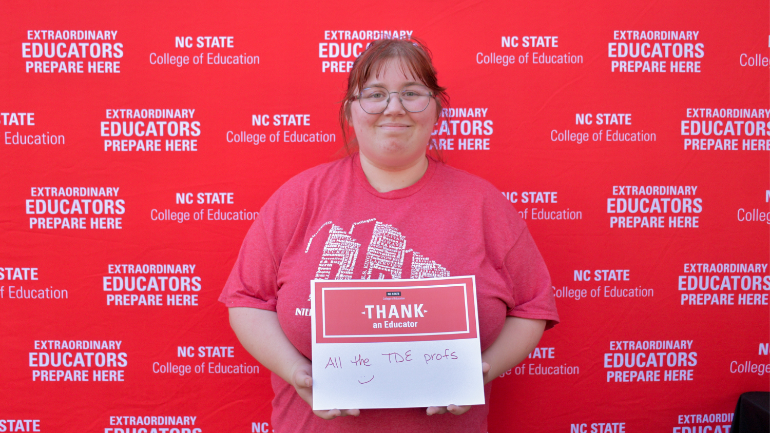 A student holding a Thank an Educator card