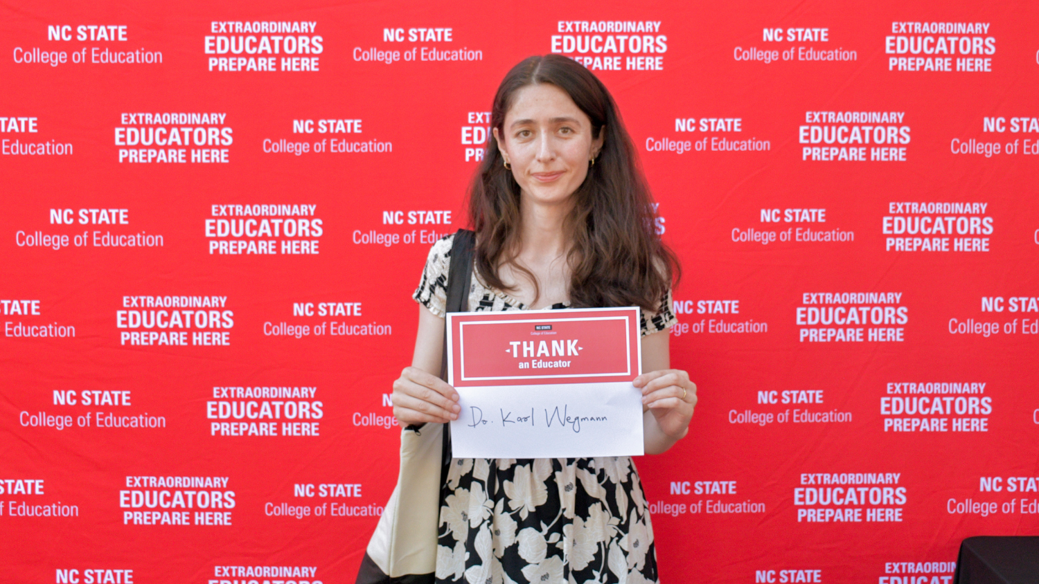 A student holding a Thank an Educator card