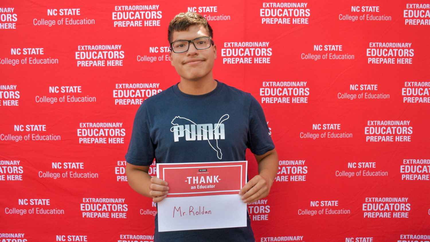 A student holding a Thank an Educator card