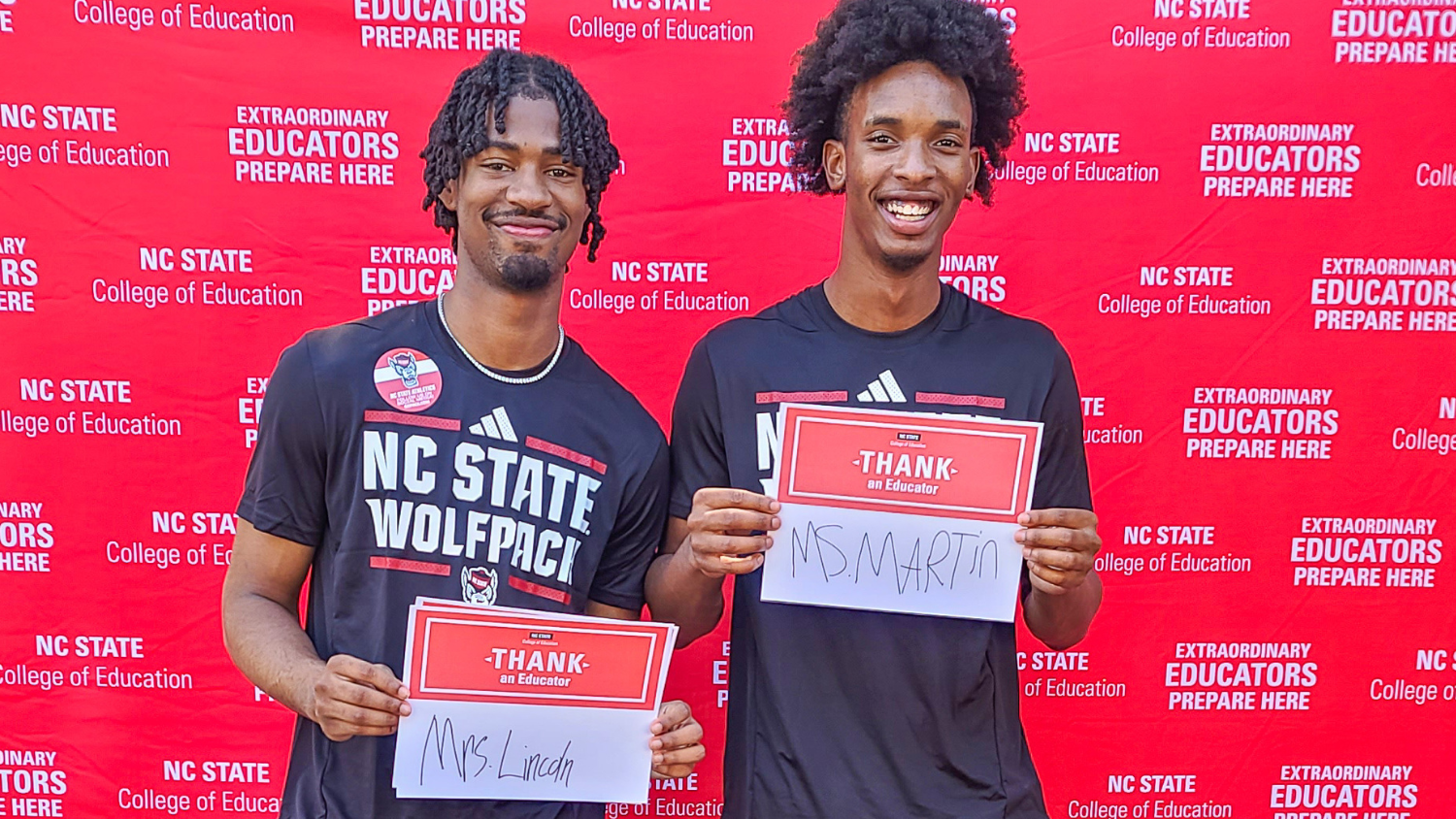 Two students holding Thank an Educator cards