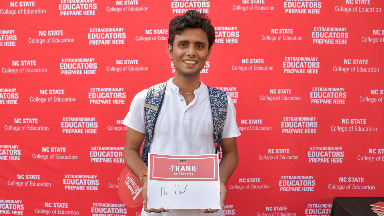 A student holding a Thank an Educator card