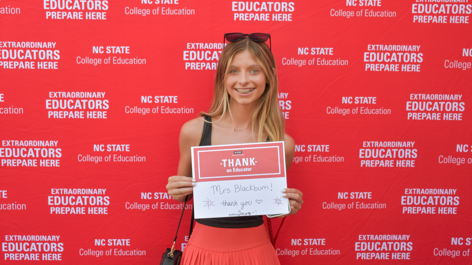 A student holding a Thank an Educator card