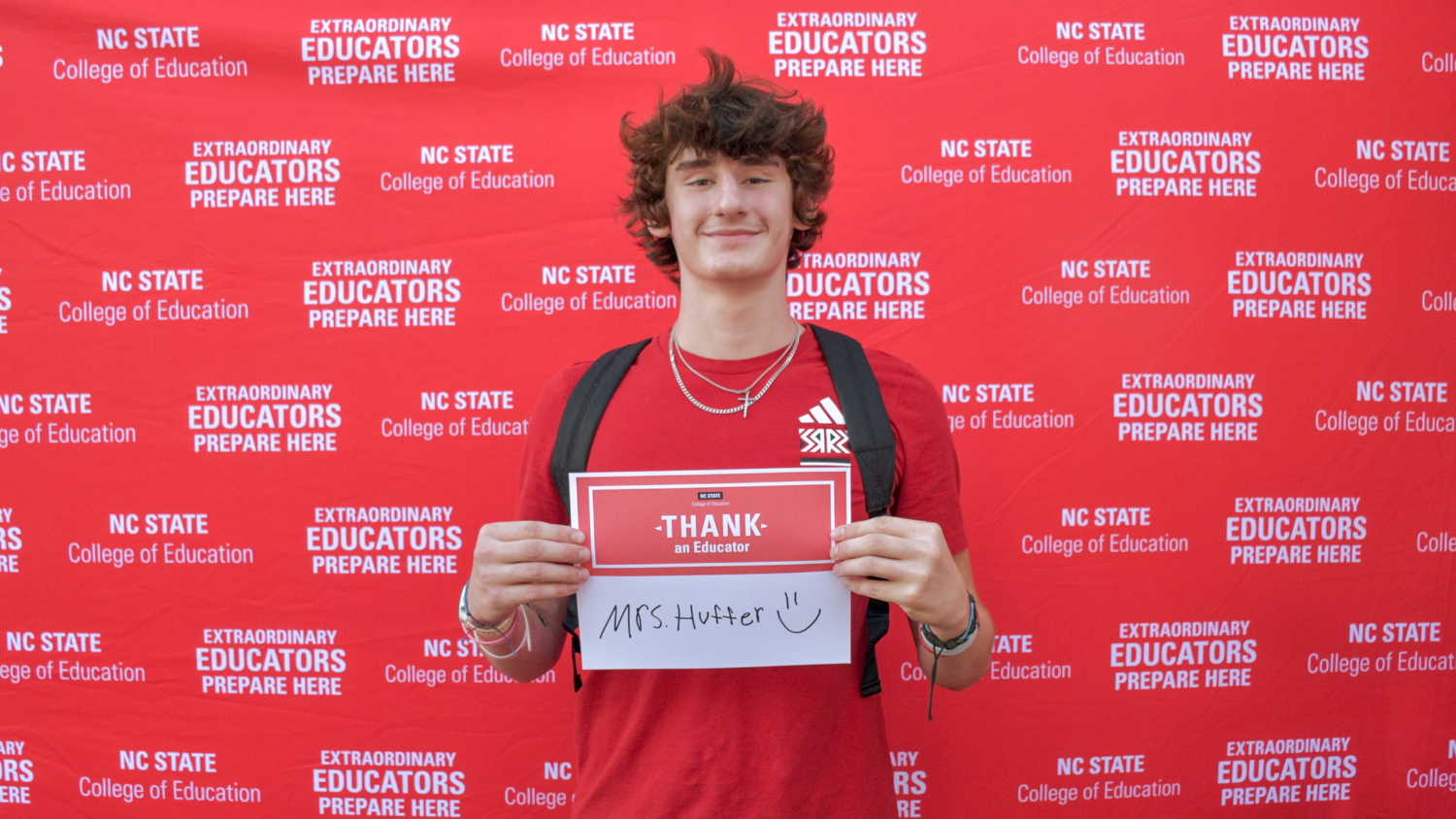 A student holding a Thank an Educator card