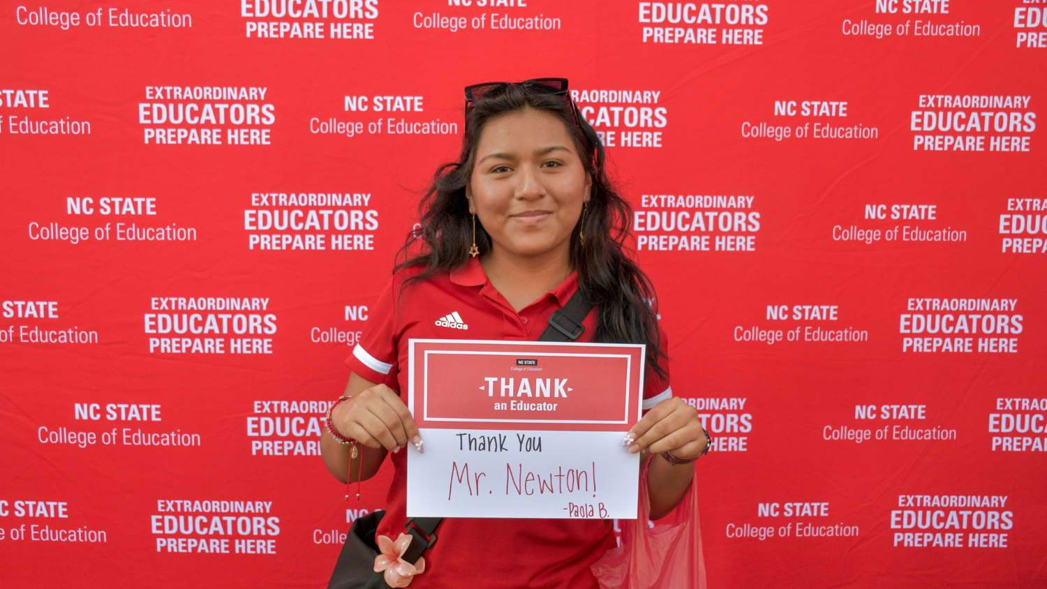 A student holding a Thank an Educator card