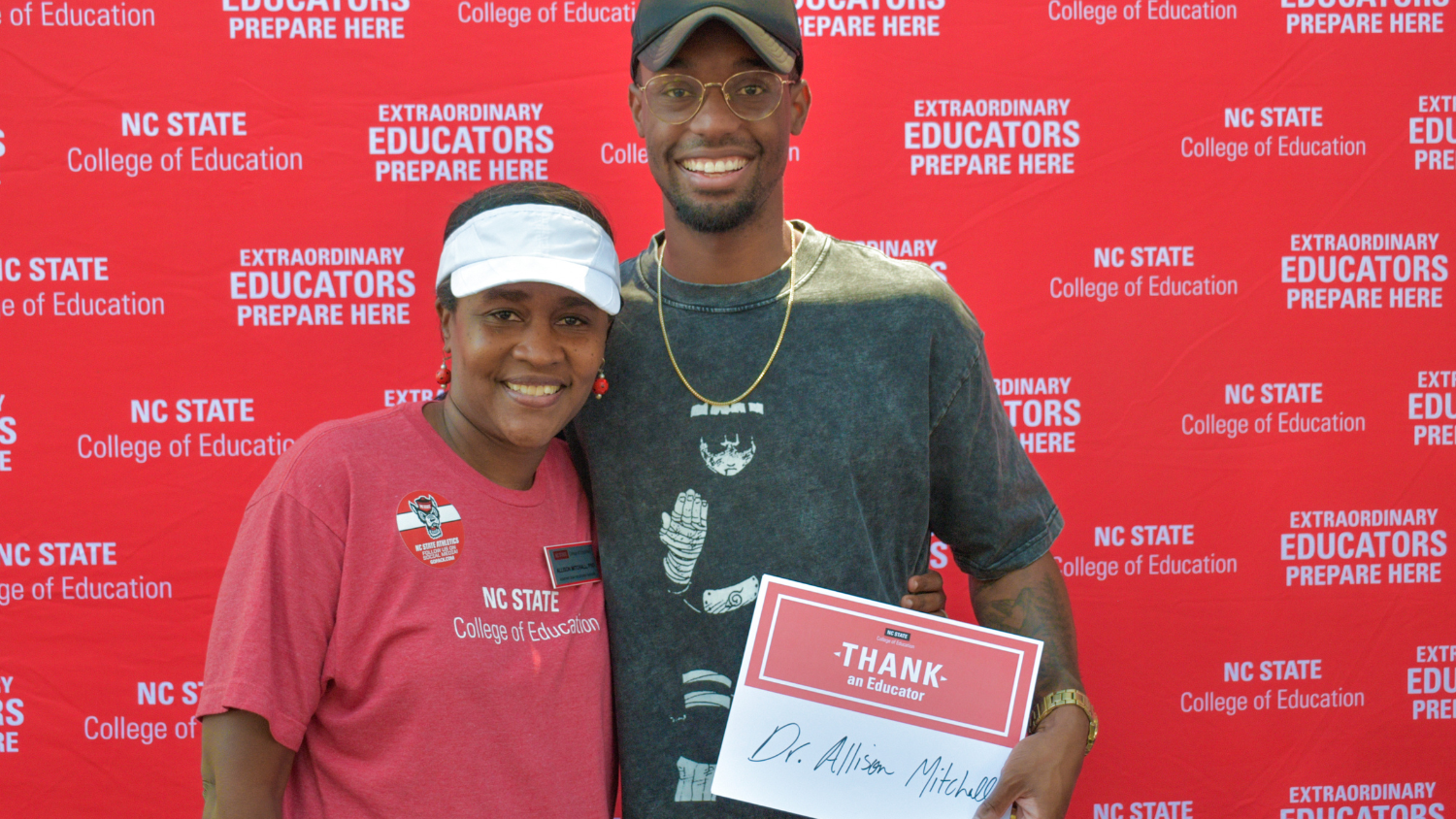 Two people holding a Thank an Educator card