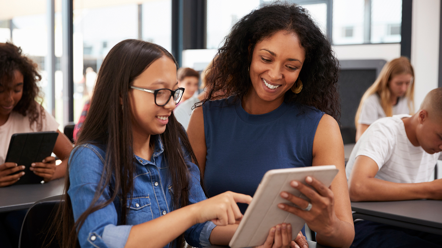 Teacher with student looking at iPad