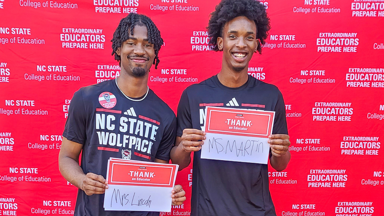 Two students with Thank an Educator cards