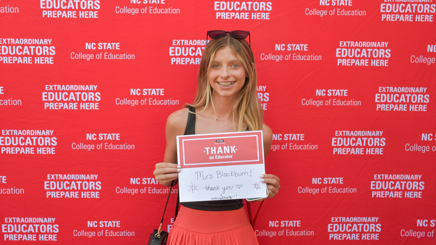 A student showing a Thank an Educator card