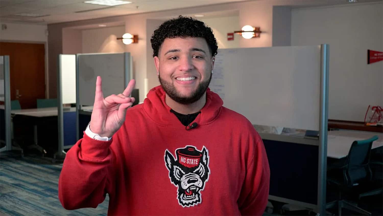 Josh Webb holding up wolf ears in a study area